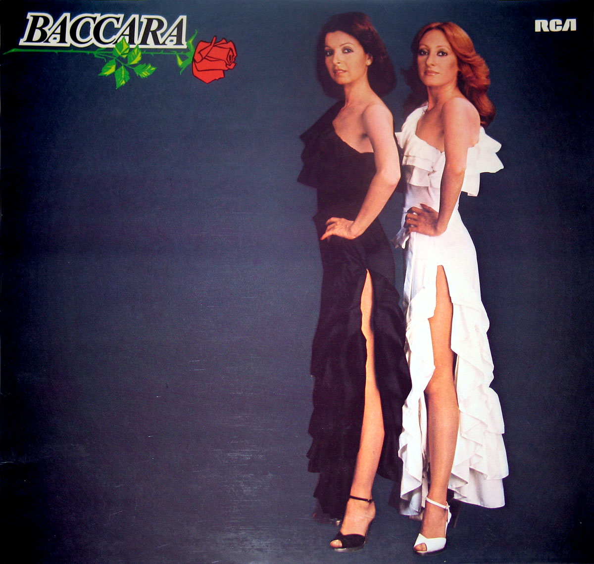 Album cover of Baccara’s self-titled album. Features the duo standing side by side, one wearing a black dress and the other in a white dress with high slits and ruffled designs. The background is dark, with the Baccara logo in the top left corner alongside a green vine and a red rose. The RCA logo is in the top right corner
